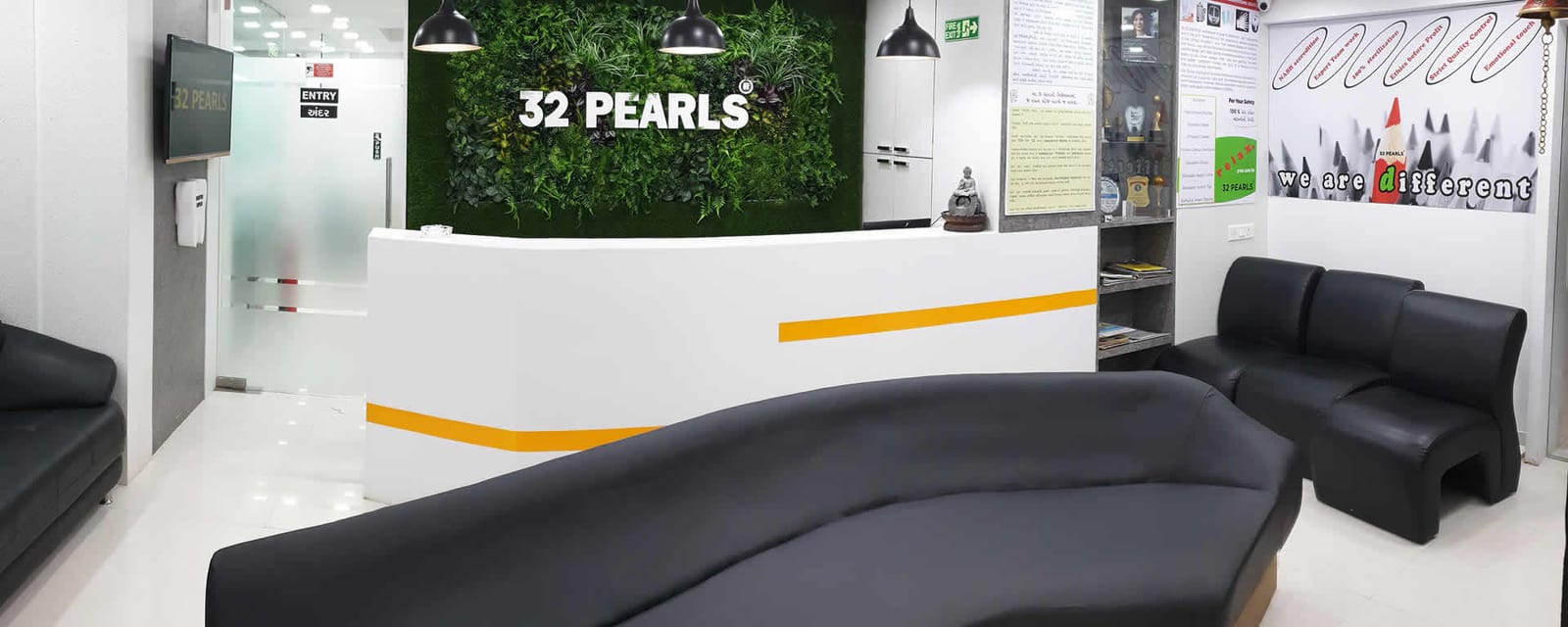Reception desk at a 32 PEARLS clinic with the 32 PEARLS sign on a green wall
