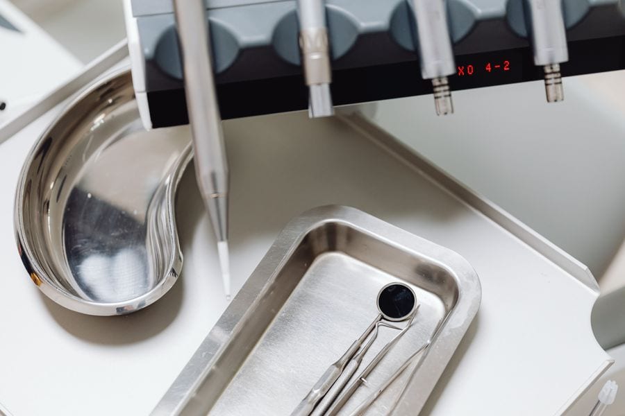 Sterile dental mirror and instruments on a steel tray